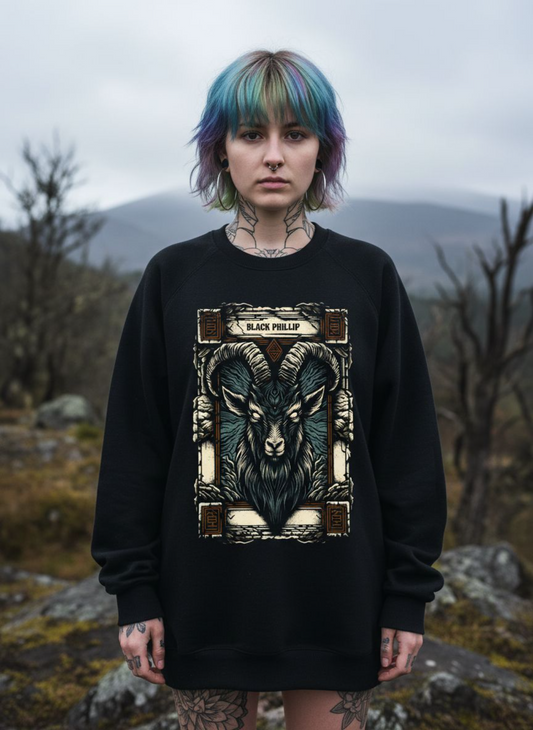 Person wearing a black sweatshirt with a goat design in a natural setting