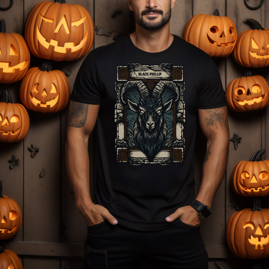 Man wearing a black t-shirt with a goat design in front of Halloween pumpkins.